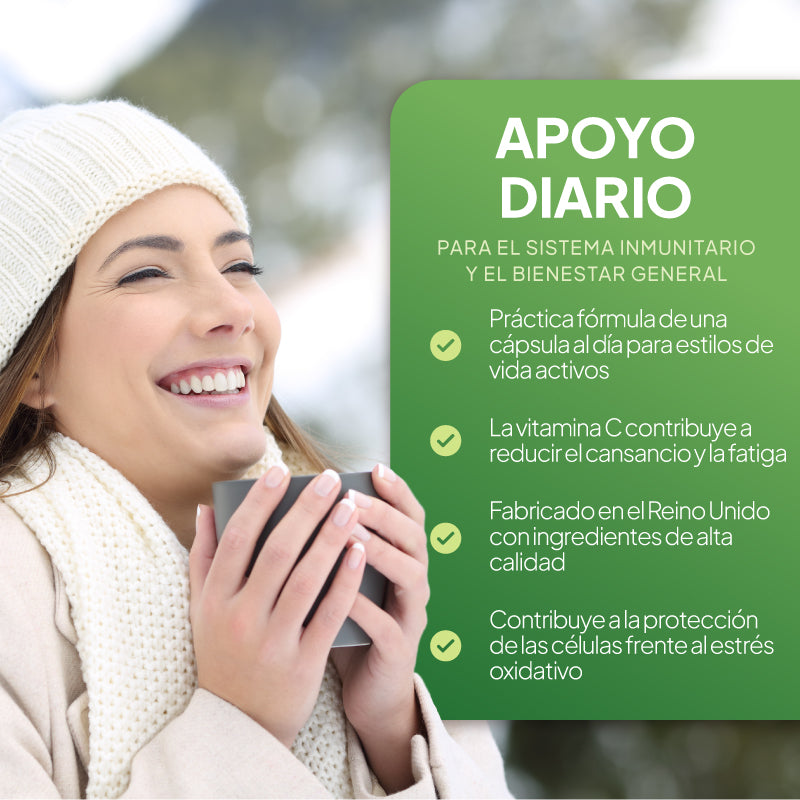 Una mujer sonriente, con un gorro de punto blanco y un abrigo color crema, sostiene una taza junto a un gran panel informativo verde en el que se lee en español «APOYO DIARIO» y se enumeran una serie de puntos sobre el refuerzo del sistema inmunitario y el bienestar general.