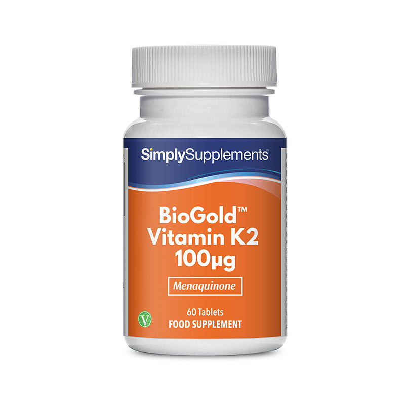 Frasco de suplemento con la etiqueta «BioGold Vitamina K2 100 mcg Simply Supplements», de color naranja sobre fondo blanco.